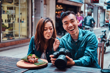 Asian couple enjoy chinese food and watching pictures