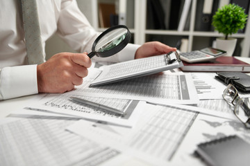 Businessman working at office and calculating finance, reads and writes reports. Business financial accounting concept.