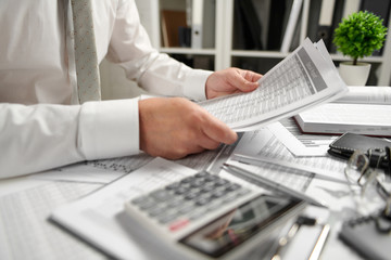 Businessman working at office and calculating finance, reads and writes reports. Business financial accounting concept.