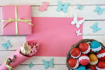 Wielkanocne tło z kolorowymi pisankami, różowym papierem, motylkami i zajączkami - obrazy, fototapety, plakaty