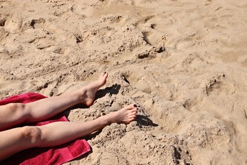 A beautiful unrecognizable Caucasian women sunbathing on a beach near Wilderness, South Africa. 