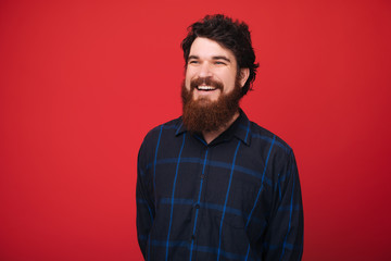 A smiling man over red background looking far away