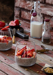 Two glasses with homemade super food chia pudding with cut strawberries