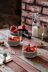 Two glasses with homemade super food chia pudding with cut strawberries