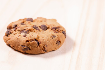 Oatmeal cookies with chocolate on a wooden background.