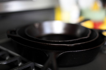 Cast iron skillets on a modern gas stove oven in a home.