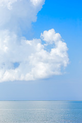 Fototapeta premium Scenic seascape with white fluffy clouds above the sea