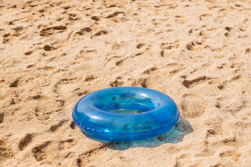 Fototapeta na wymiar Blue inflatable swimming circle on the sand