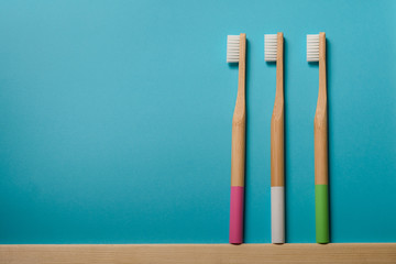 full colours bamboo toothbrushes on blue background. Place for text. Ecoproduct. 
