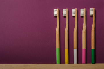 full colours bamboo toothbrushes on liliac background . Place for text. Ecoproduct.   eco-friendly