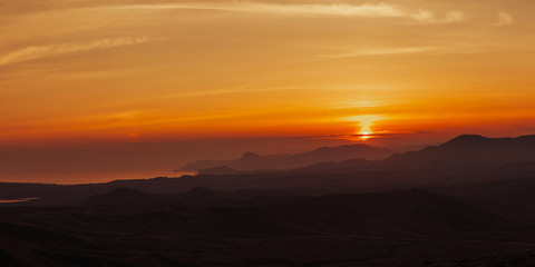 Golden sunset in the mountains by the sea