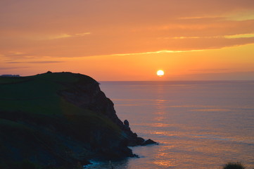 Fototapeta na wymiar Orange sun in a sunset at the cantabrian coast, Ruiloba, Cantabria