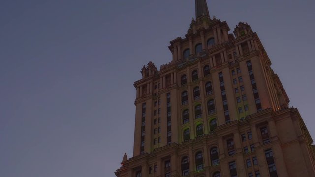 Beautiful old building. One of the seven skyscrapers built by Stalin order in Moscow. The image slides down the building and back. Side and bottom view. Evening. Art Deco style. The original facade