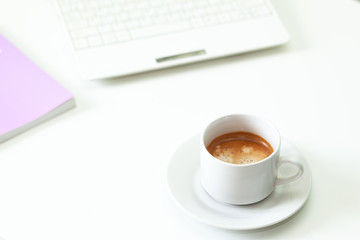 Coffee cup , laptop and lavender notpad on white table. Selective focus.