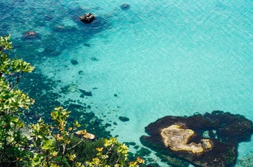 Fototapeta na wymiar Vibrant top view of blue sea water and rocks
