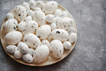 Composition of white traditional dotted Easter eggs in white ceramic plate