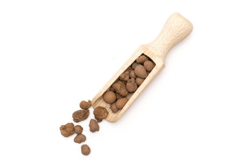 Lot of whole brown clay pebbles (leca) with wooden scoop flatlay isolated on white background