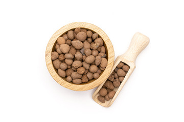 Lot of whole brown clay pebbles (leca) with wooden bowl and wooden scoop flatlay isolated on white background