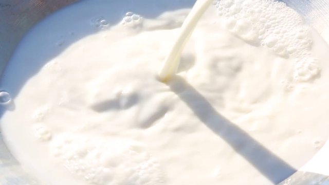 Pouring milk into the bowl.  Natural milk.  Close up. 