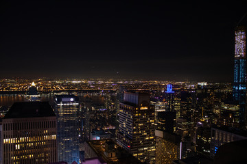 Night time aerial view of Manhattan in New York City showing the classic high rise buildings and city scape in the USA