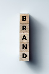 a line of wooden cubes with the inscription "brand", on an uneven white background. Vertical frame