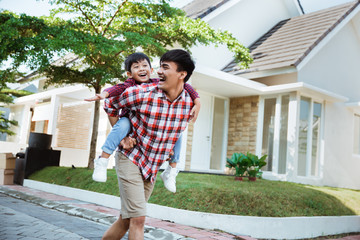 son enjoy riding on his father's back in the morning at their house
