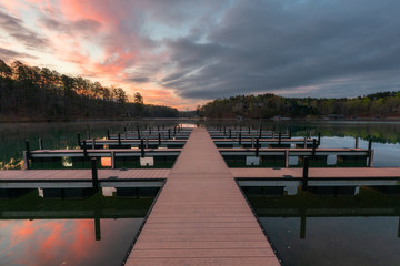 symmetrical dock on lake during colorful sunrise