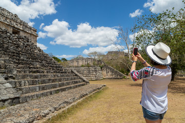 Tourist in the archaeological area takes pictures on the smartphone. Ancient Maya city of Ek Balam. Archaeological zone of the ancient Mayan civilization, Yucatan, Mexico