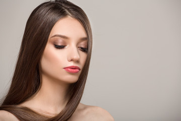 Naklejka premium Woman with straight shiny hair. Gray background
