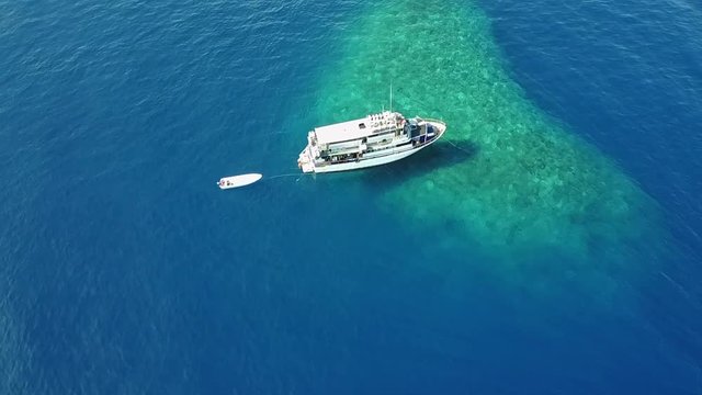 Drone pulling away from Dive Boat on Coral Reef
