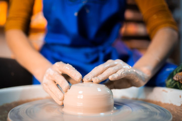 Working process of man's work at potters wheel in art studio. Unknown craftsman creates jug. Focus on hands only. Small business, talent, invention, inspiration concept