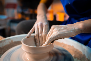Working process of man's work at potters wheel in art studio. Unknown craftsman creates jug. Focus...