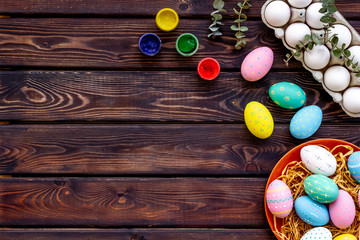 Fototapeta na wymiar Colorful eggs for easter on wooden background top view mockup