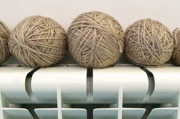 Gray wool yarns for home knitting and white home heating radiator.