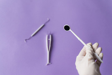 Dentist's hand and dentall instruments on colorful background