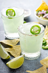 Salted rim spicy iced margarita with jalapeno, limes and chips