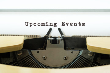 Upcoming Events word typed on a yellow vintage typewritter. Business concept.