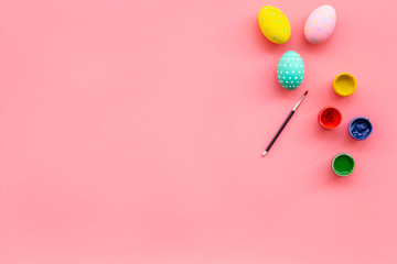 Fototapeta premium Colorful Easter eggs and paint for celebration on pink background top view mock up