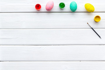 Colorful Easter eggs and paint for celebration on white background top view mock up
