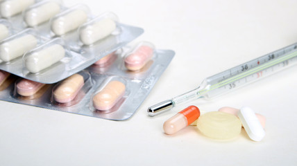 Pharmacy theme, tablets, pills capsule heap mix therapy drugs with medicine antibiotic and thermometer. Close up of capsules. Medicine background for medical concept.