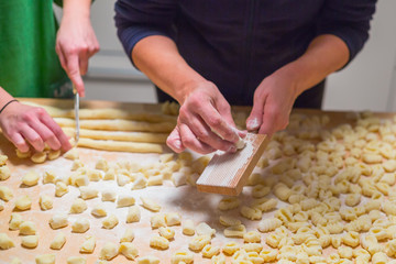 Cooks hands preparing raw pumpkin gnocchi 
