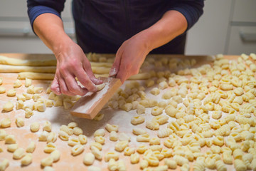 Cooks hands preparing raw pumpkin gnocchi 