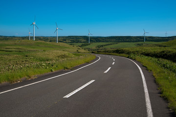 Fototapeta na wymiar 宗谷丘陵を行く道と発電用風車