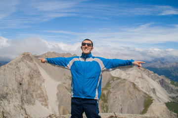 Man Traveler on mountain summit enjoying aerial view hands raised over clouds Travel Lifestyle success concept adventure active vacations outdoor happiness freedom emotions