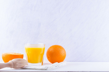 Orange fruits with juice, concept. Orange juice and halves of oranges on white background. Citrus for making juice and manual juicer. Whole and squeezed oranges and glass of juice