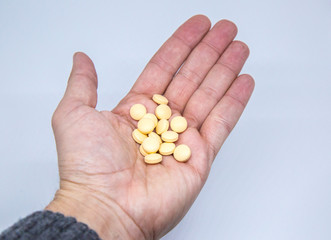 Medicine pills or capsules in elder hand