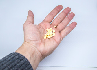 Medicine pills or capsules in elder hand