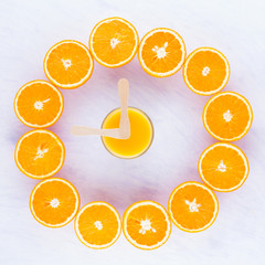 Fruit Dial. Creative idea of the clock from the halves of oranges fruit. Citrus watches, concept. Halved oranges on white background. Top view