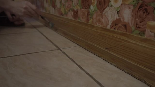 hands lacquered wooden baseboards
