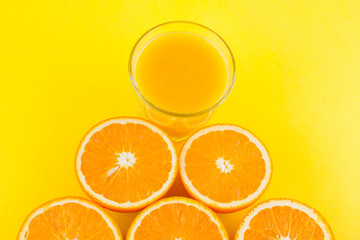 Cut halves of juicy orange on yellow blue background. Orange fruit, citrus minimal concept. Creative summer food minimalistic background. Top view, copy space